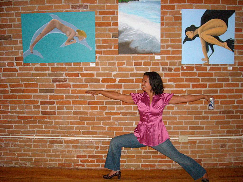 Sammie doing a yoga pose underneath her art work at Old Town Yoga.