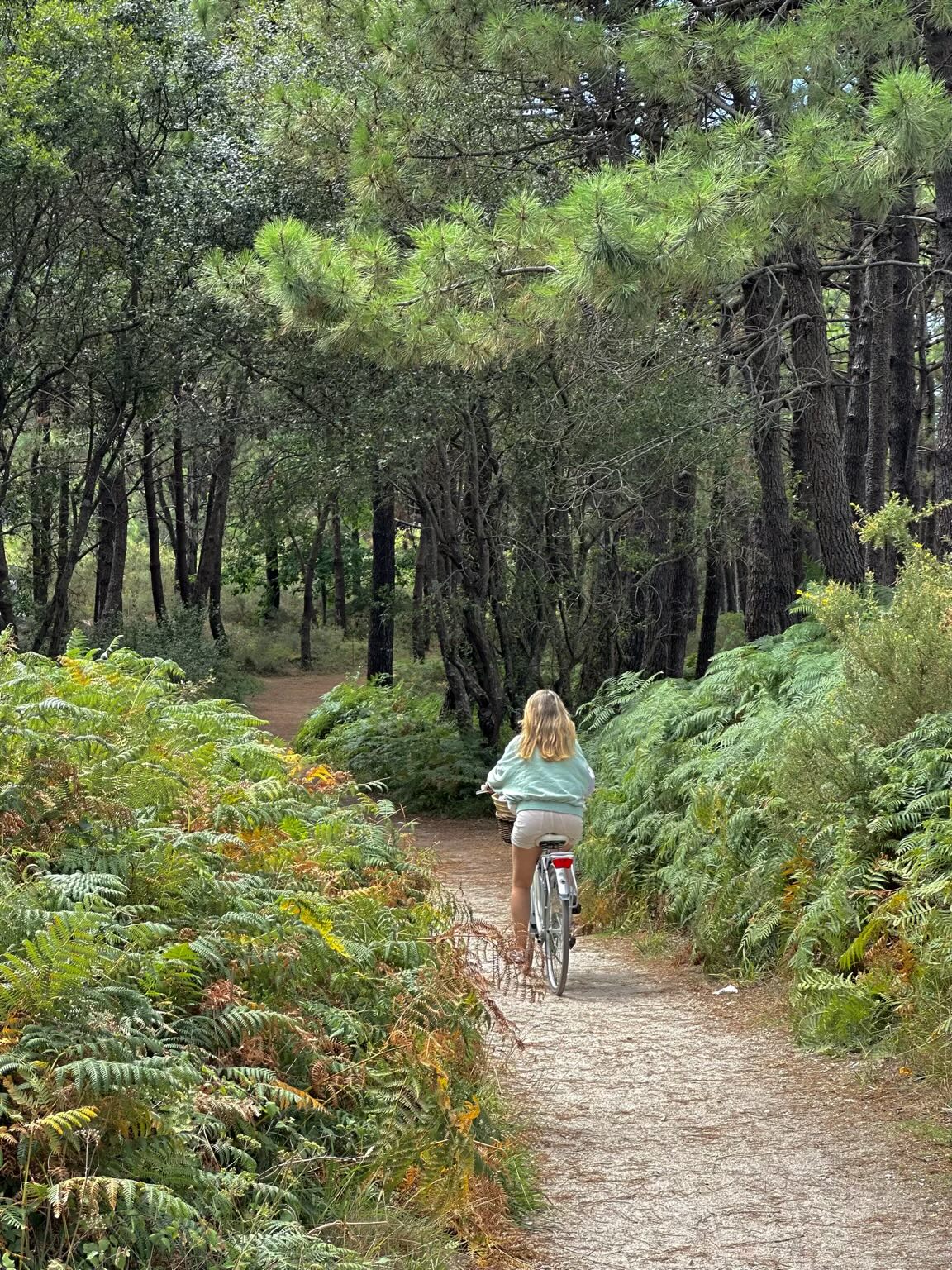 Andrea biking through trees on A Illa de Arousa.