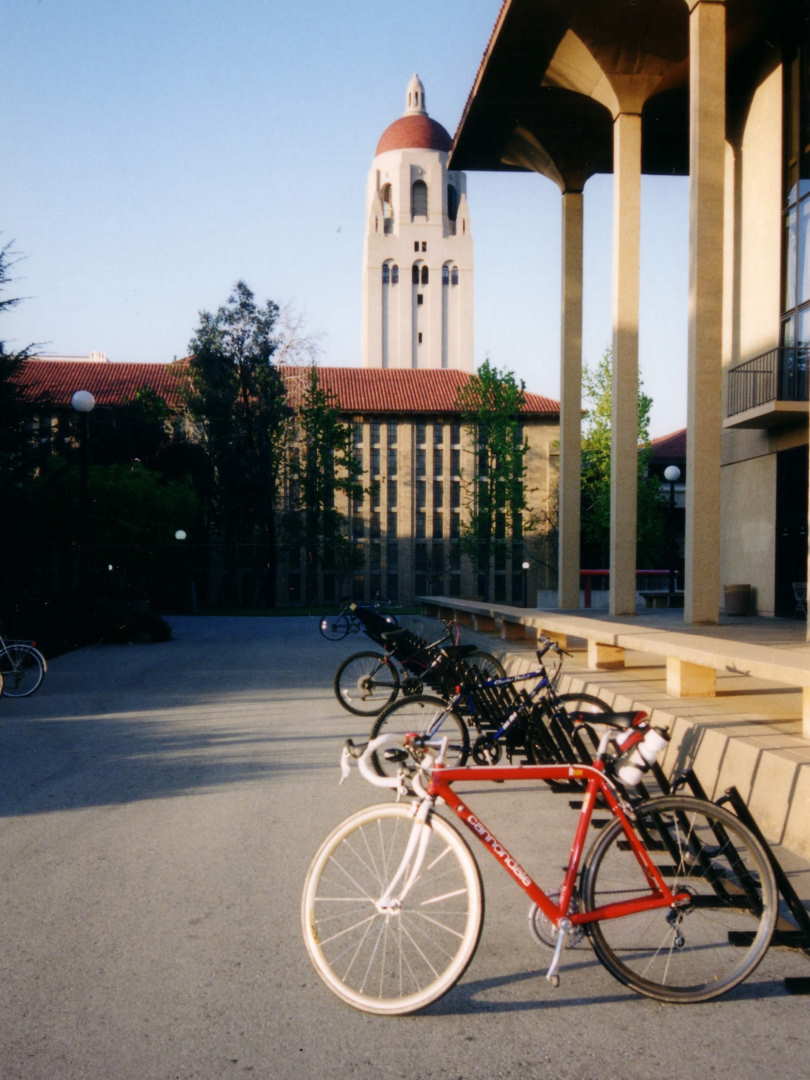 red 1992 Cannondale R500 3.0 with white fork in front of Meyer Library, Green Library, and Hoover Tower at Stanford University
