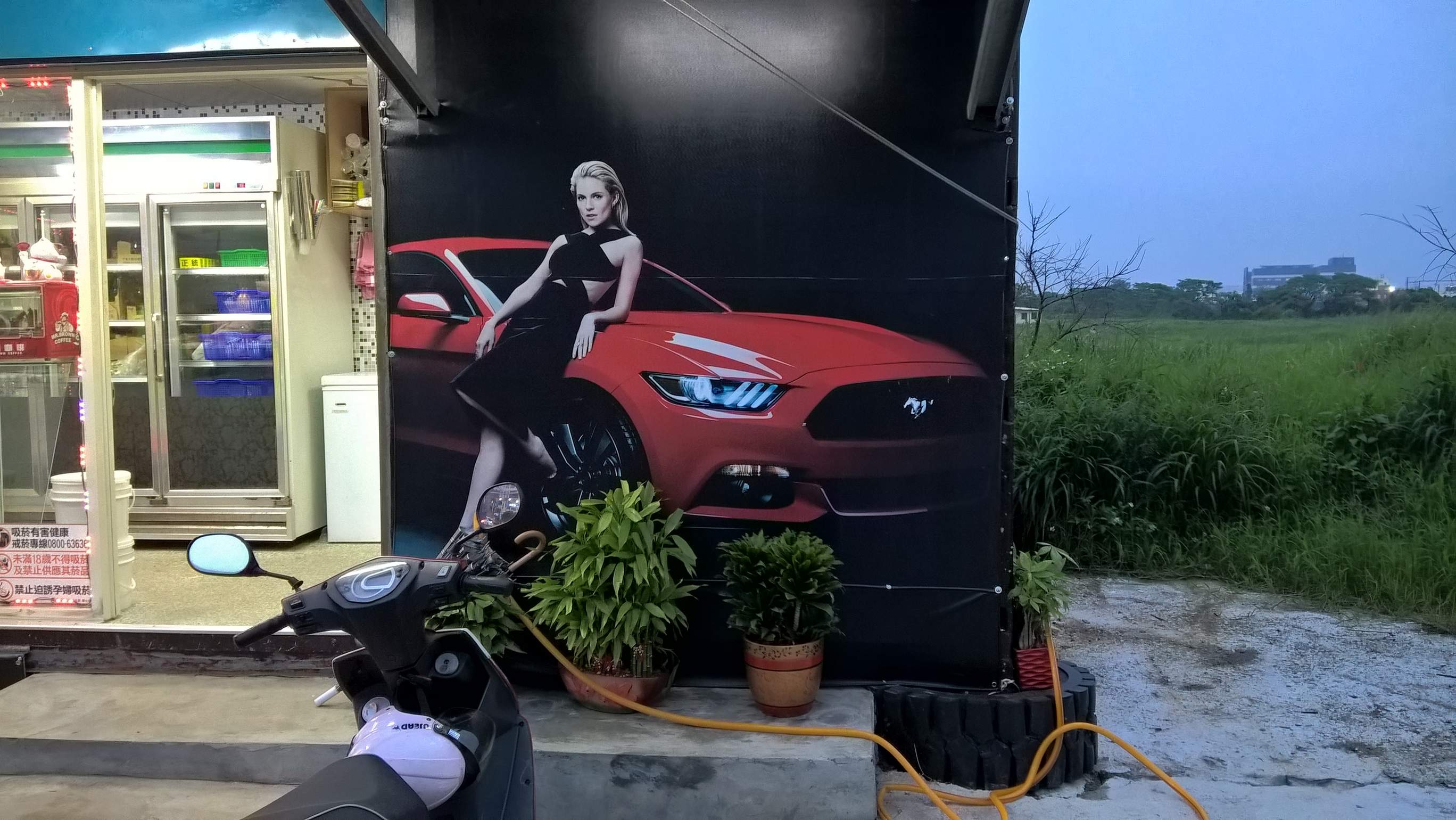 Woman standing against red 2016 Ford Mustang Coupe.