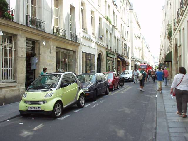 Environmentally-conscious, space-efficient hatchbacks are big in Europe.  Here is a Smart vehicle (in yellow/green), followed by a Renault Clio (I think?), a Fiat Punto (in red), a motorcycle, and a Peugeot 206 in the 7th arrondissement in Paris.