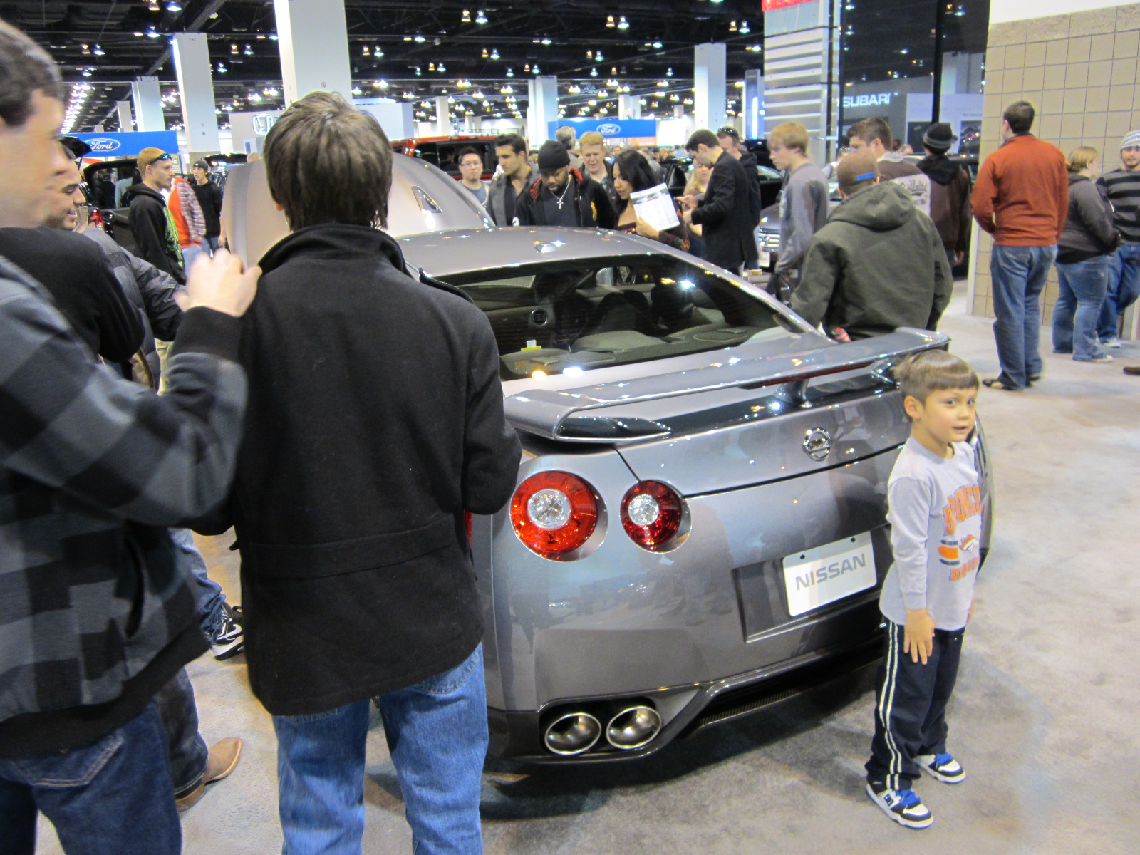 Kid obscuring the rear of the Nissan GT-R (supposedly capable of 0-60 in 2.6 seconds).