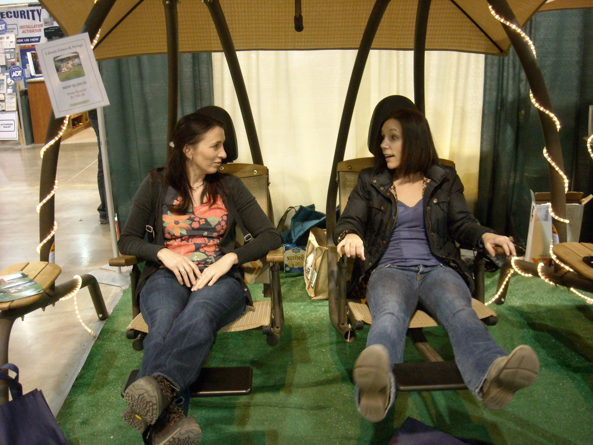 Tori and Lisa relaxing on a $4000 patio swing set.