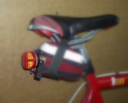 saddle bag under bicycle saddle with emergency ID tag and rear LED light attached to it