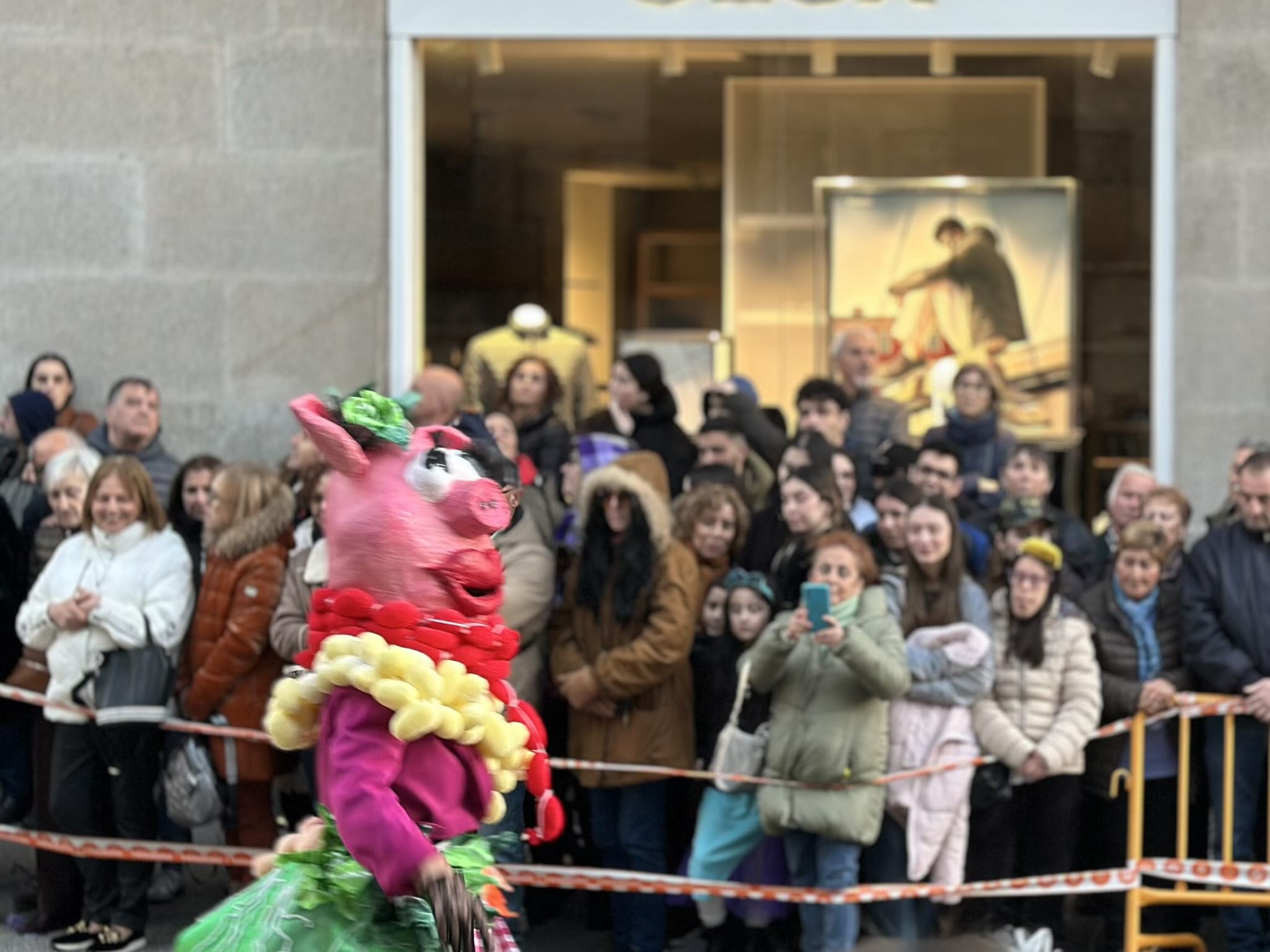 A pig character wearing a hula hoop and green skirt during Entroido.