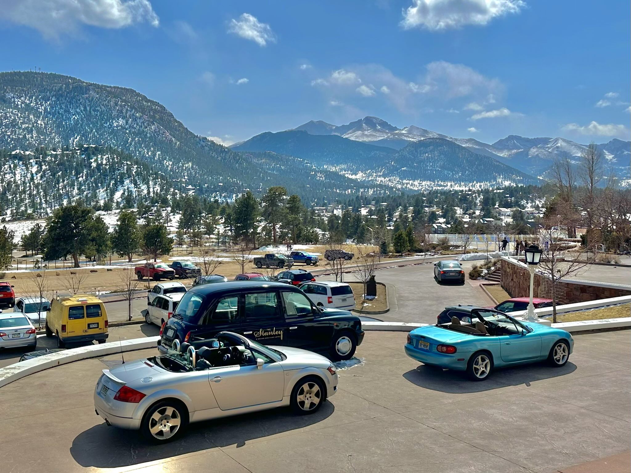 My silver Audi TT Roadster, a black London Taxi, and Manuel's sky blue miata at the Stanley Hotel. The Rocky Mountains are in the background.