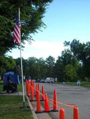 flagpole with U.S. flag, many orange cones lining street