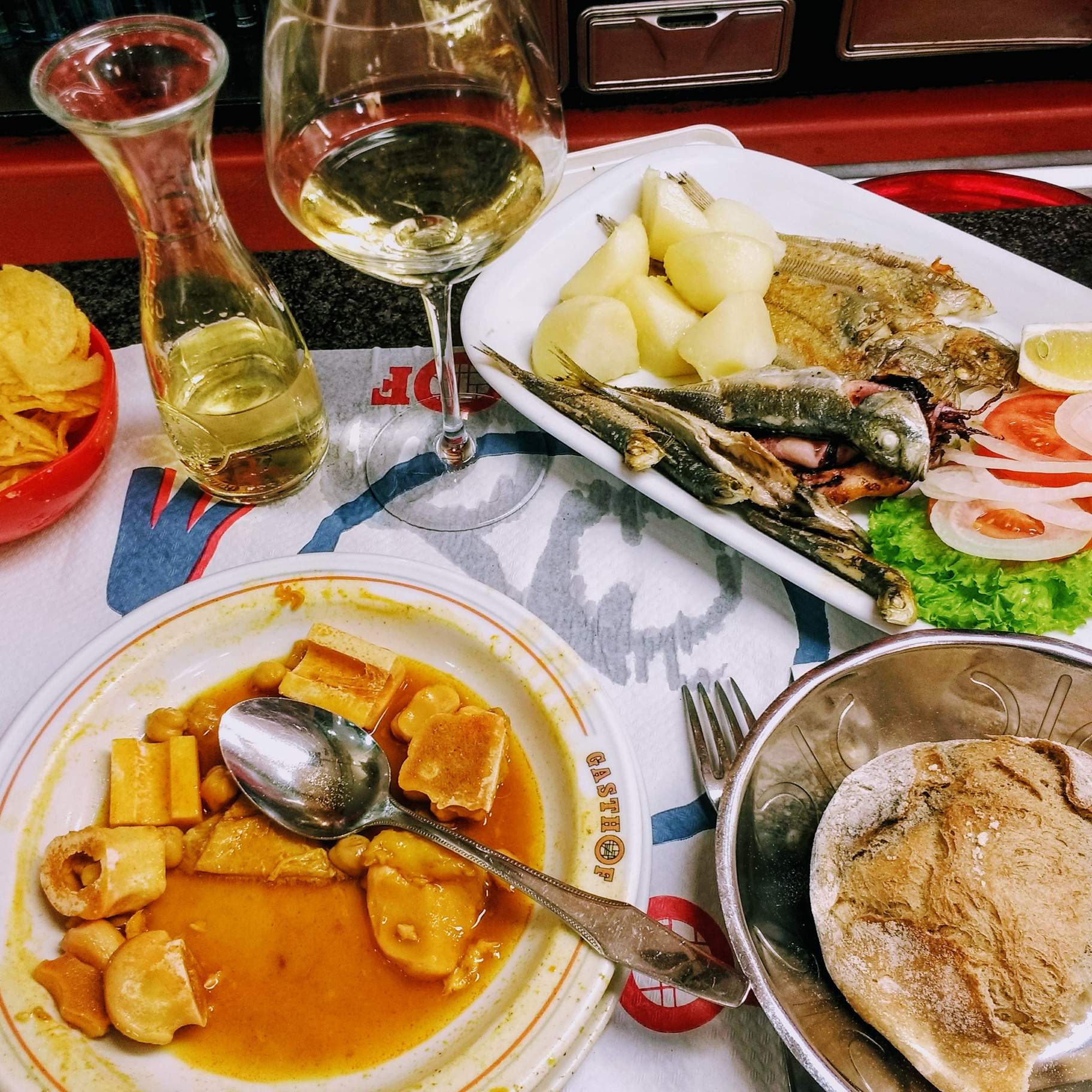 The menú del día with chips, a beef and potato stew, bread, white wine, mixed fish, potatoes, and some vegetables. It also came with dessert (not shown), for which I selected Tarta de Santiago (kind of a yellow cake).  All this cost less than 10 euros.