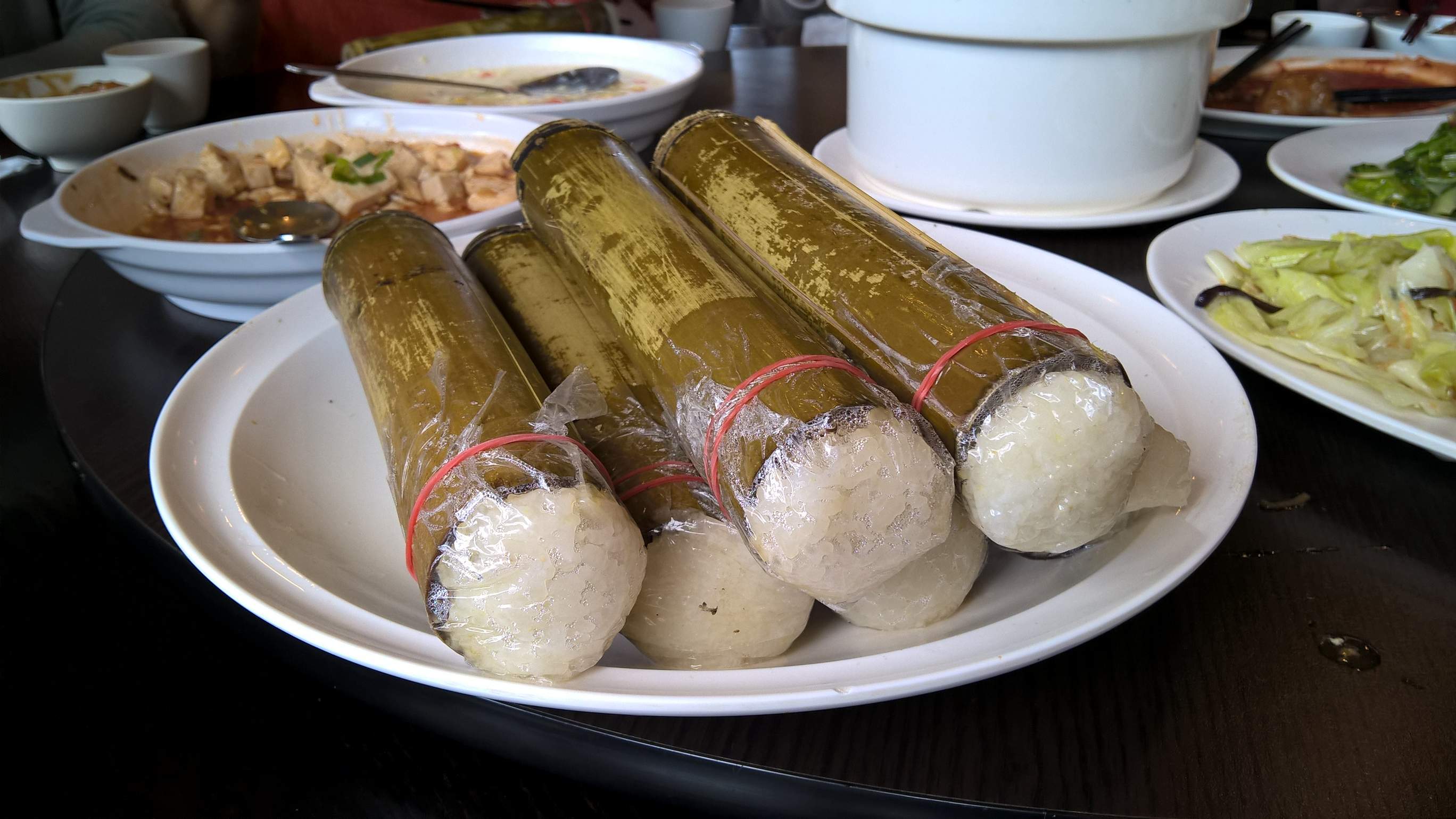 Rice cooked inside of large tubes of bamboo.