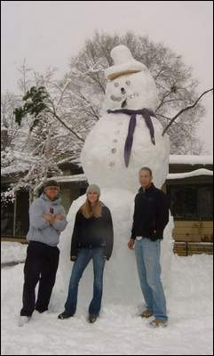Three people in front of a giant snowman in Fort Collins.
