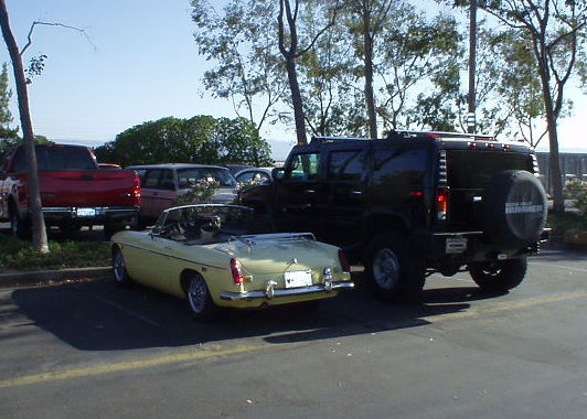 yellow 1969 MGB next to black Hummer H2 SUV