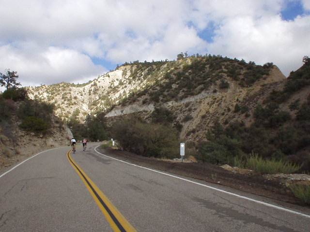 Mile 126, 4:05 p.m.: Cyclists riding out of the saddle.  See that diagonal horizontal ridge right above the midline of the picture?  We'd be going up that in just moments!