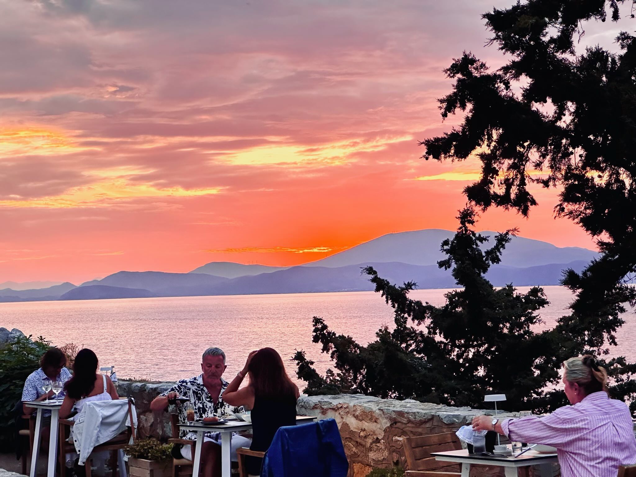 The view of a sunset by Techne Restaurant on Hydra Island.