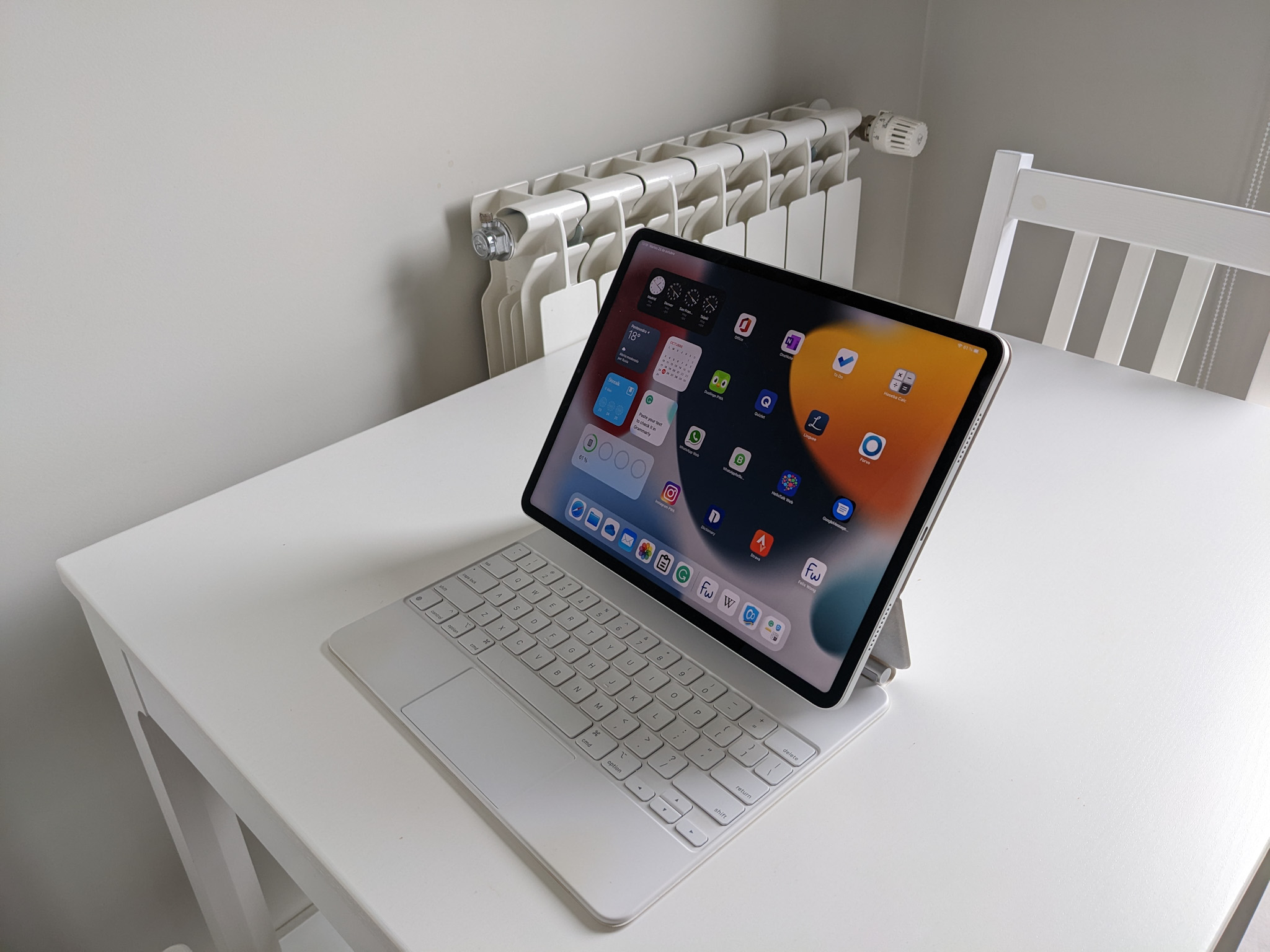 A white iPad Pro 12.9 and Apple Magic Keyboard on a white table.