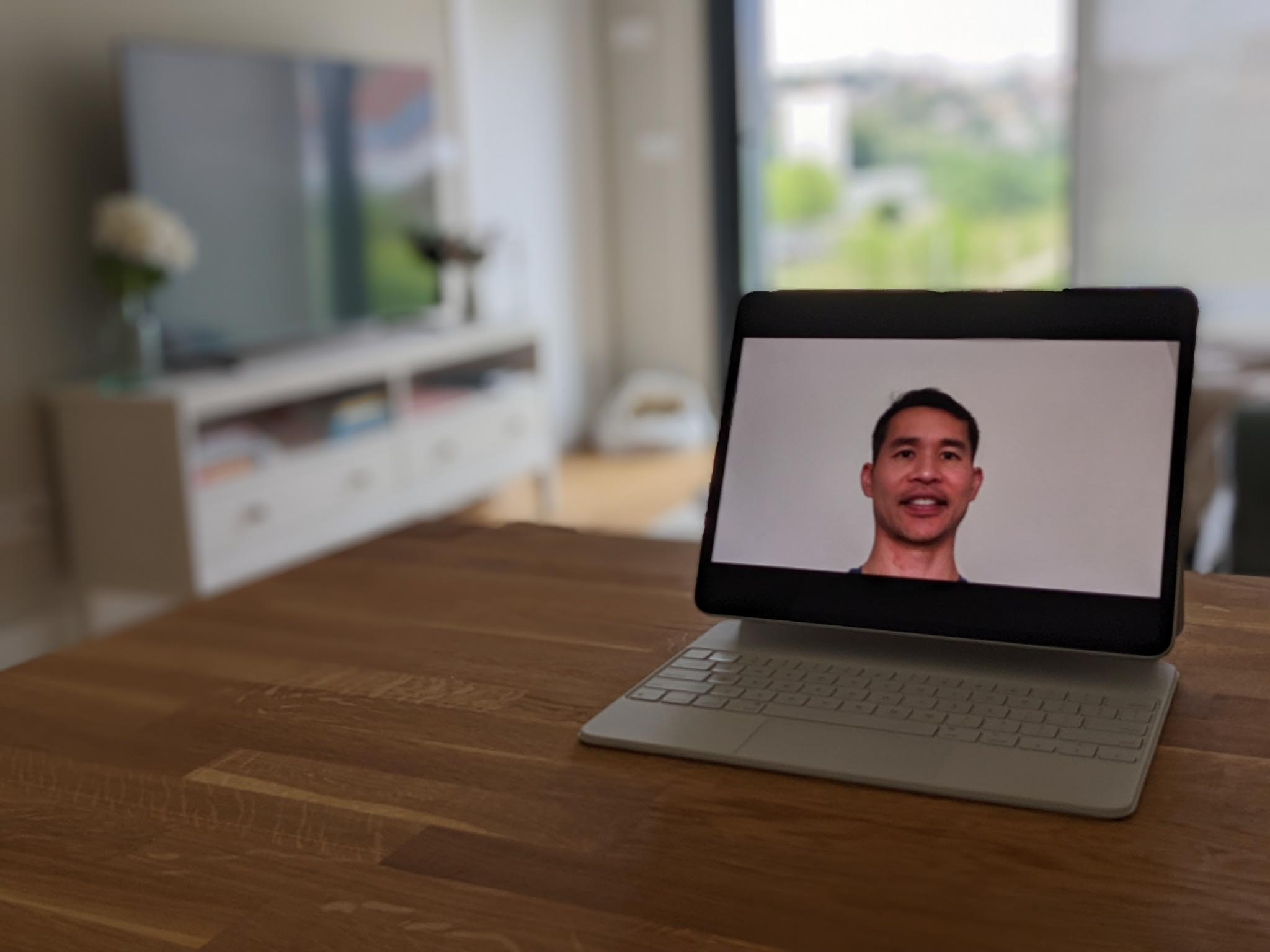 Videoconferencing on Zoom using a white iPad Pro 12.9 with Apple Magic Keyboard.