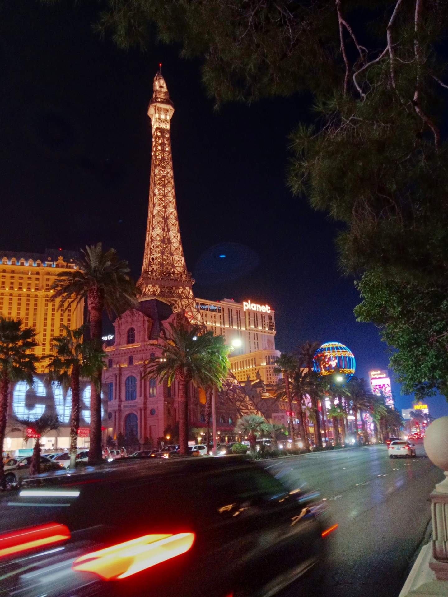 A car wizzing by the faux Eiffel Tower on the Las Vegas strip.