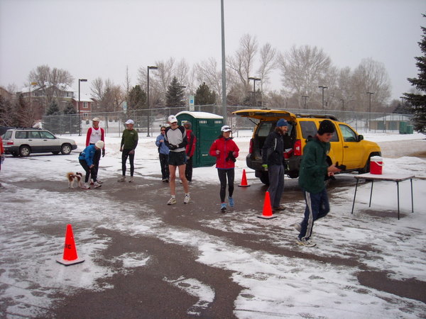 ten runners standing in ice- and snow-covered parking lot
