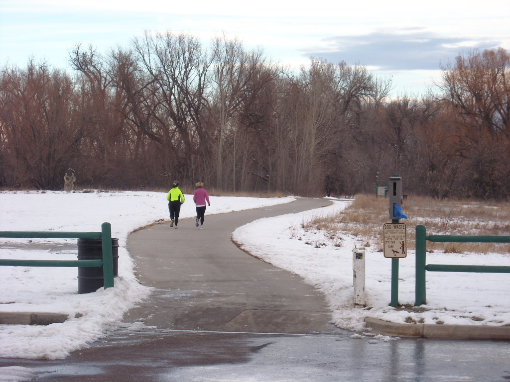 two runners including Cathy Morgan on Poudre Trail with snow on the sides
