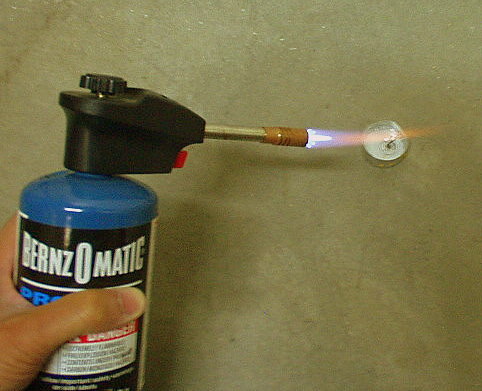 Lighting a tea candle with a Bernz O Matic blowtorch.