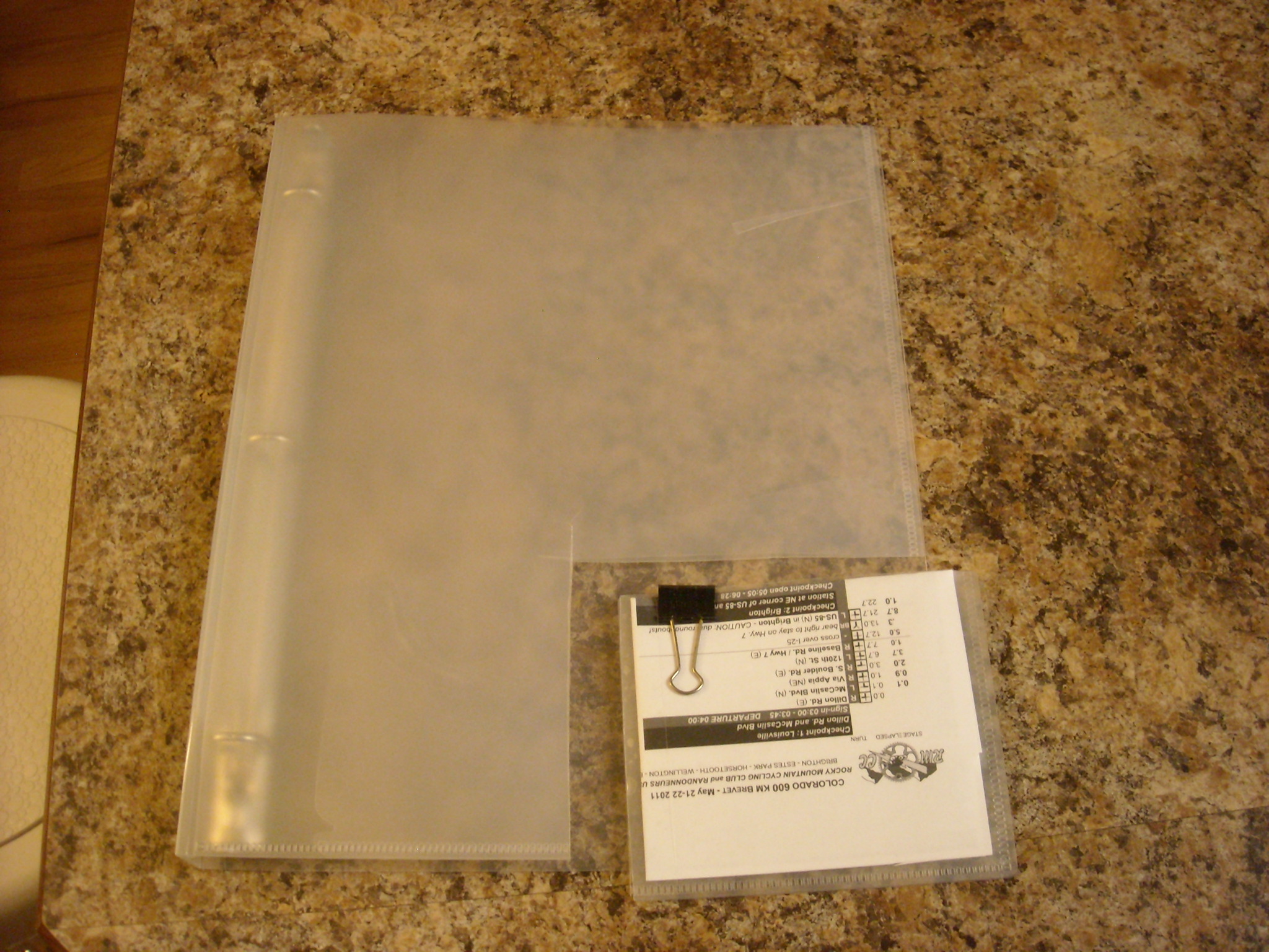 Cutting down the binder to a more appropriate size (5 inches X 4 inches).  Two pieces of plastic are then joined together by clear tape to create a "pocket."