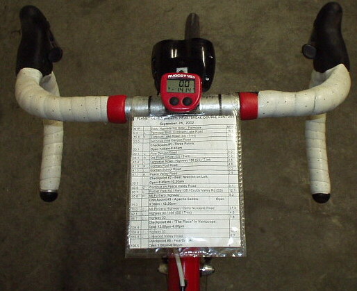 cycling route sheet inside homemade mapholder zip-tied to handlebars of road bike