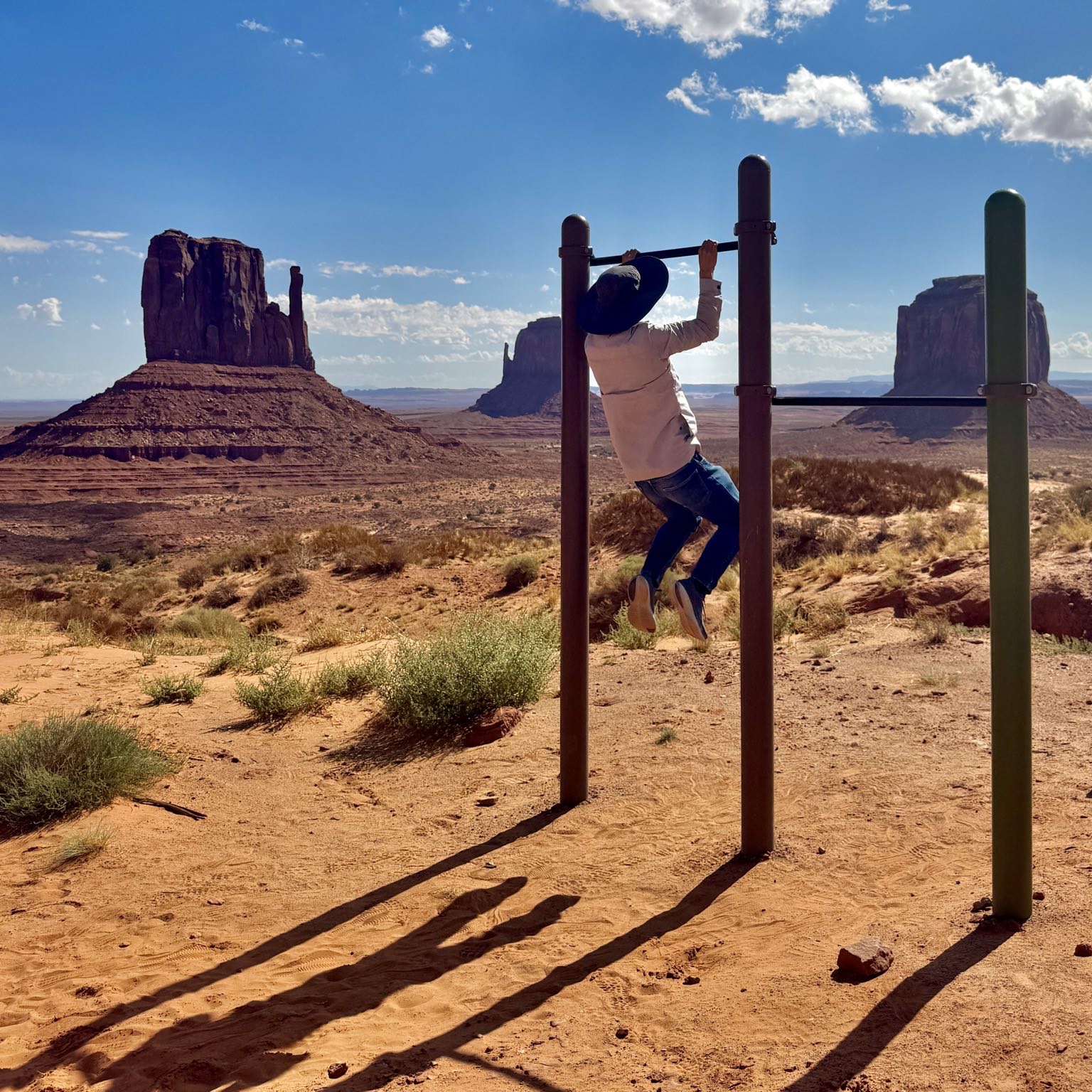 Felix doing pull-ups at Monument Valley Navajo Tribal Park, with West Mitten Butte, East Mitten Butte and Merrick Butte in the background.