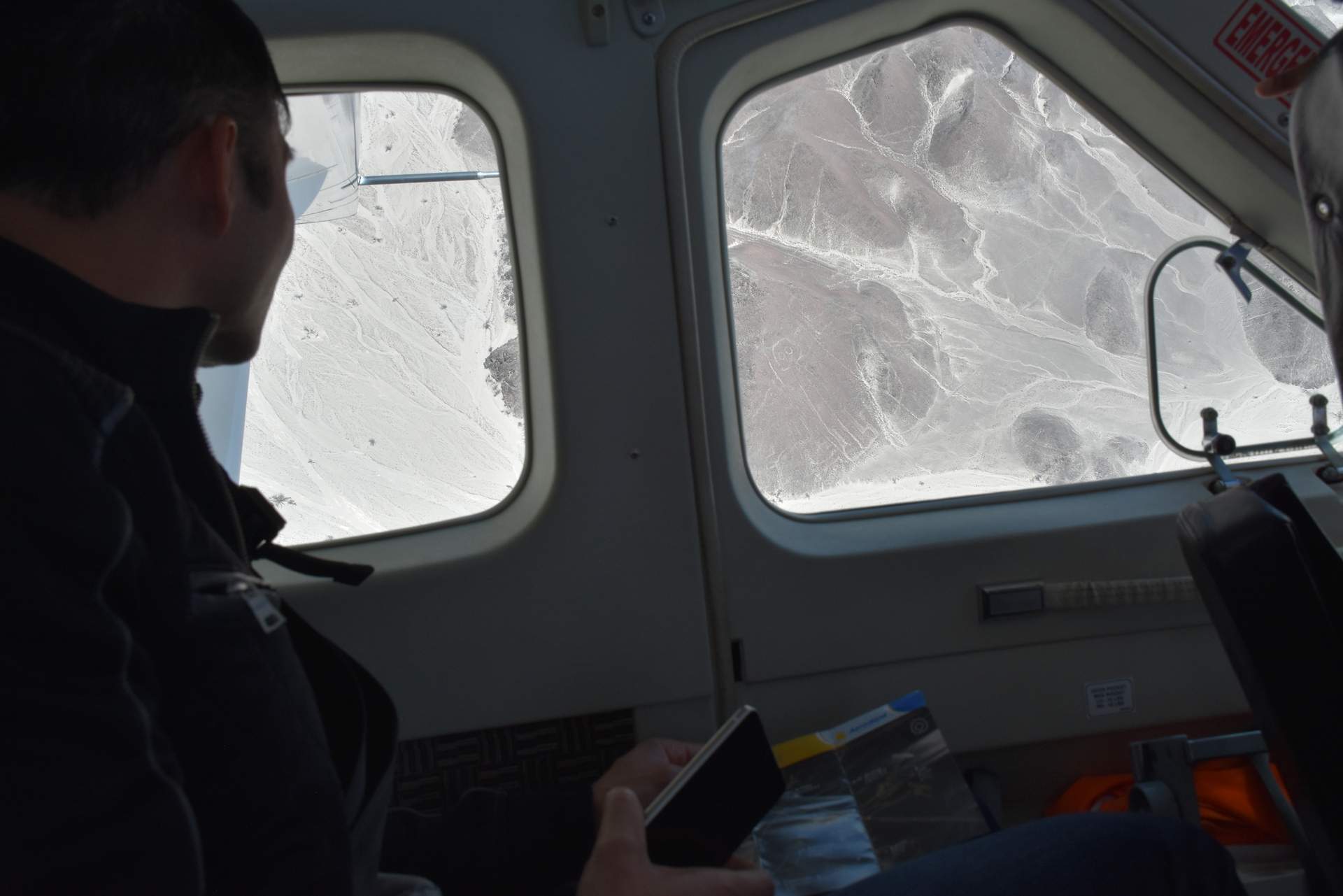 Felix Wong looking out the window of the airplane to view the Nazca Lines.