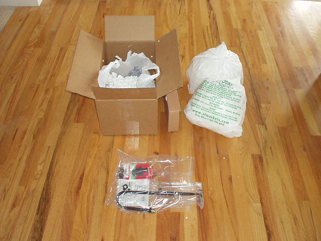 brown cardboard box and white plastic bags containing a lot of Styrofoam chips that came with a few unbreakable MGB parts
