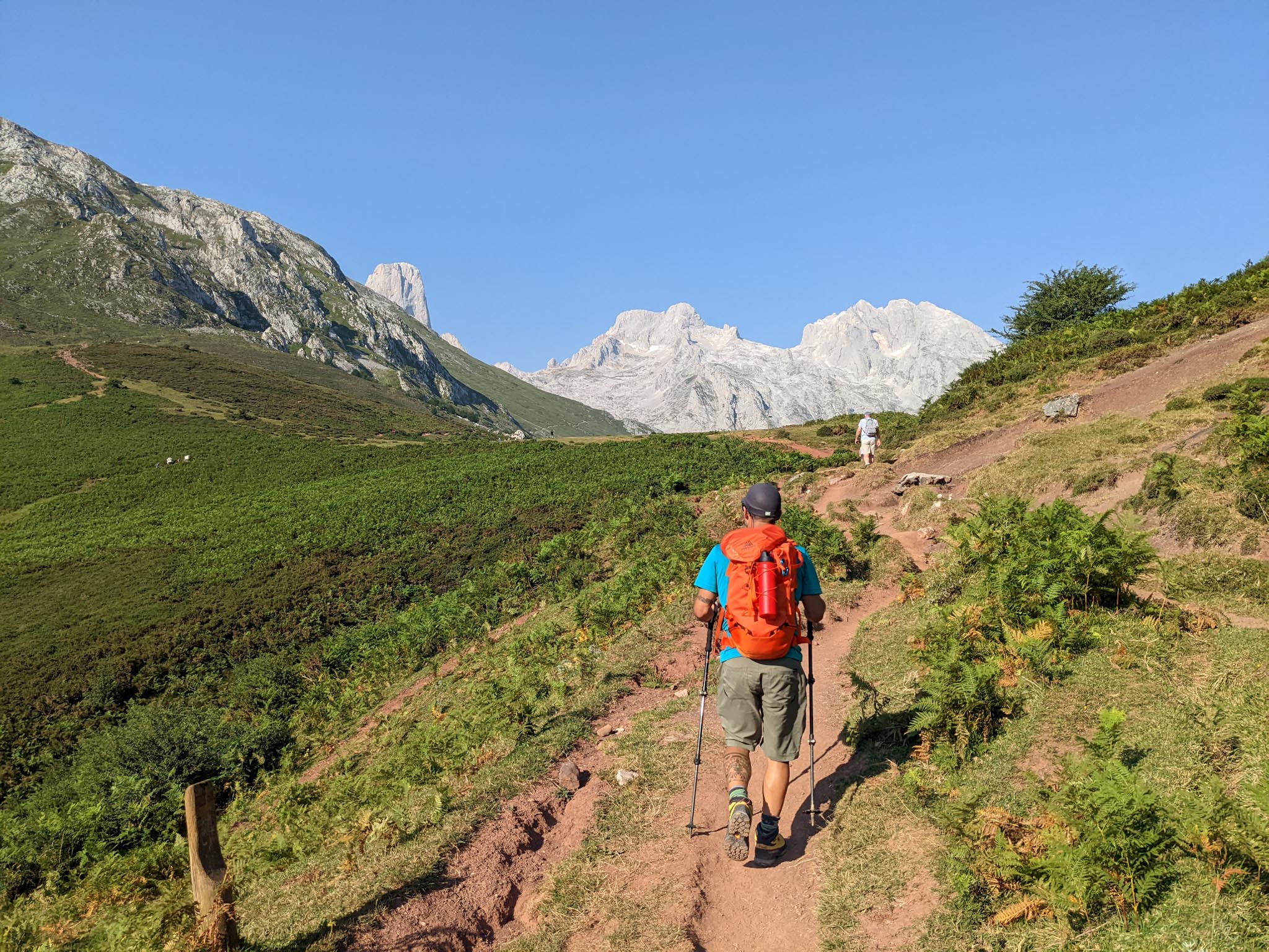 Marcos hiking with trekking poles towards rocky peaks in Picos de Europa, Asturias.