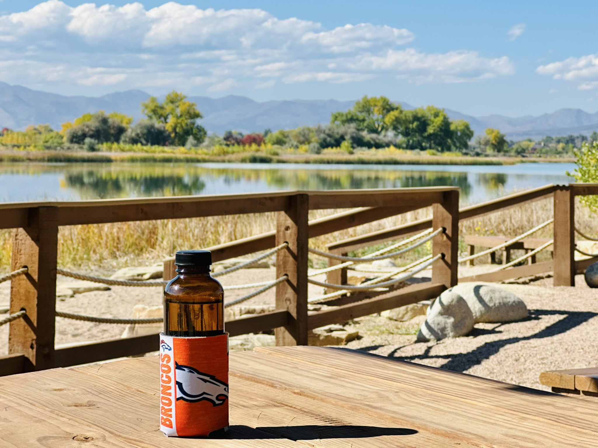 Andrea's de-stickered kombucha bottle with Broncos koozie at Richards Lake.
