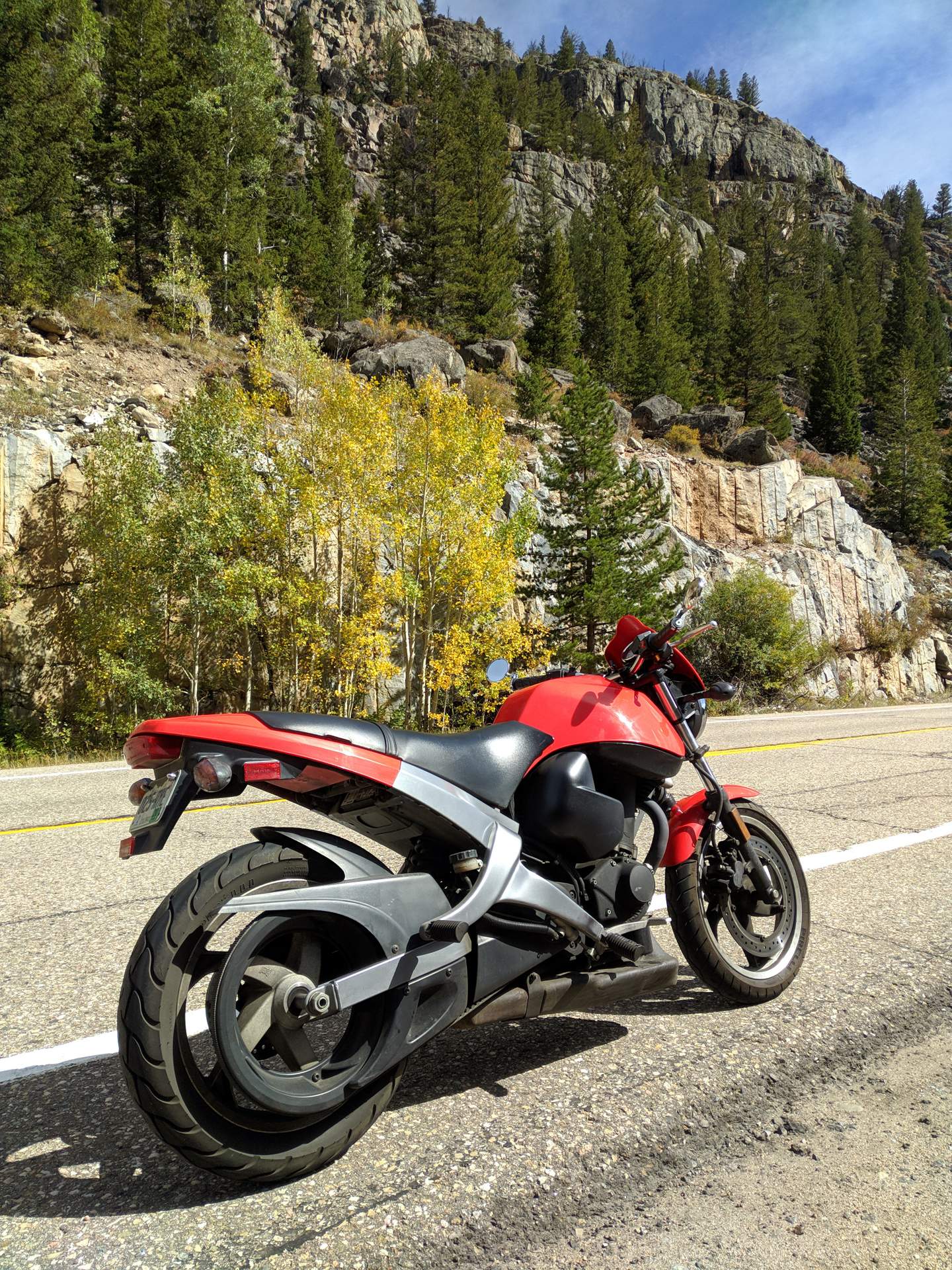 My red 2003 Buell Blast with some yellow aspens in the background..