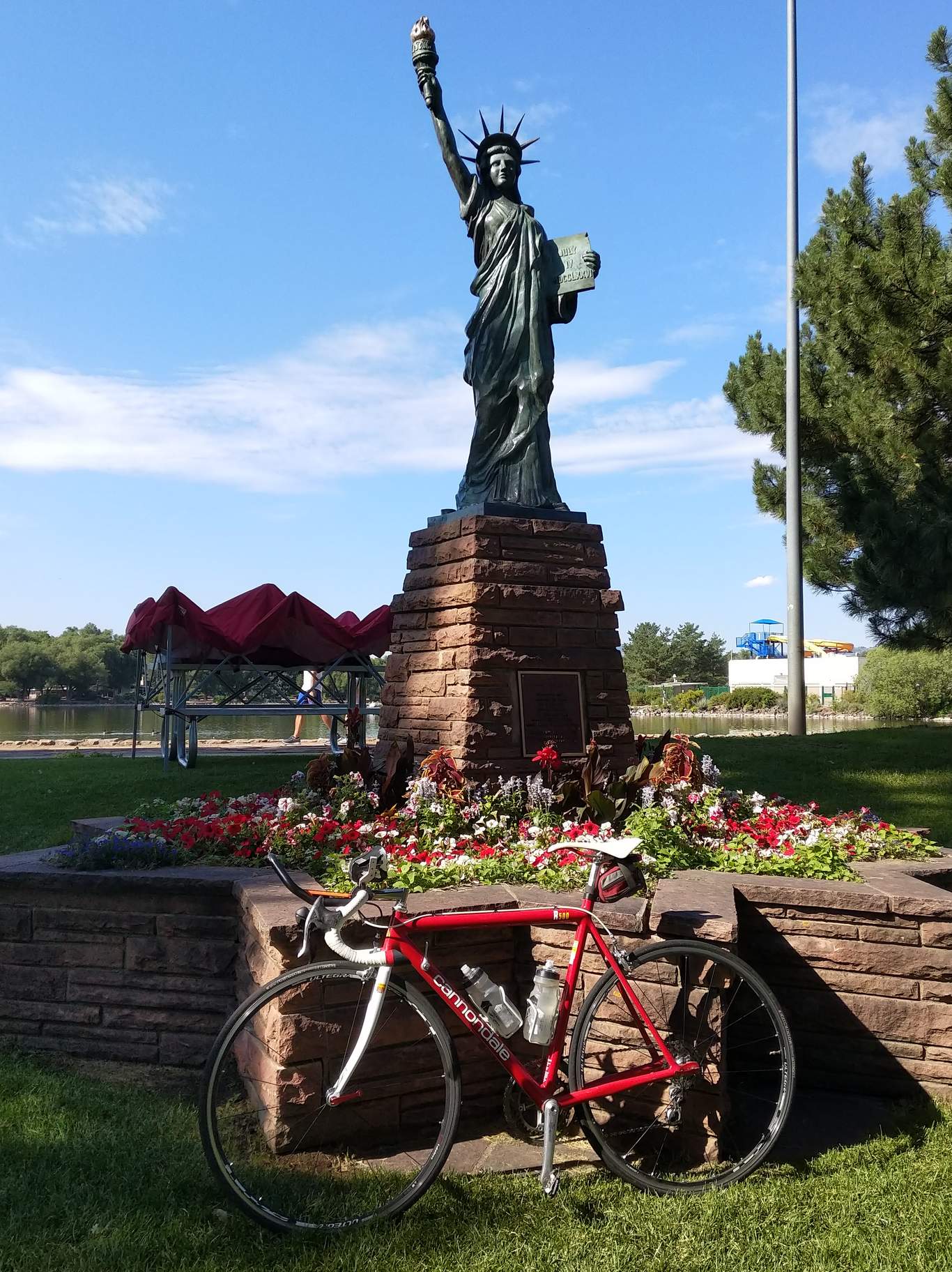 Red 1992 Cannondale R500 3.0 with white fork in front of the Statue of Liberty in Fort Collins' City Park.