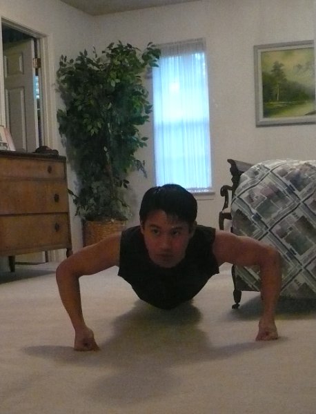 Felix Wong doing a pushup in a bedroom