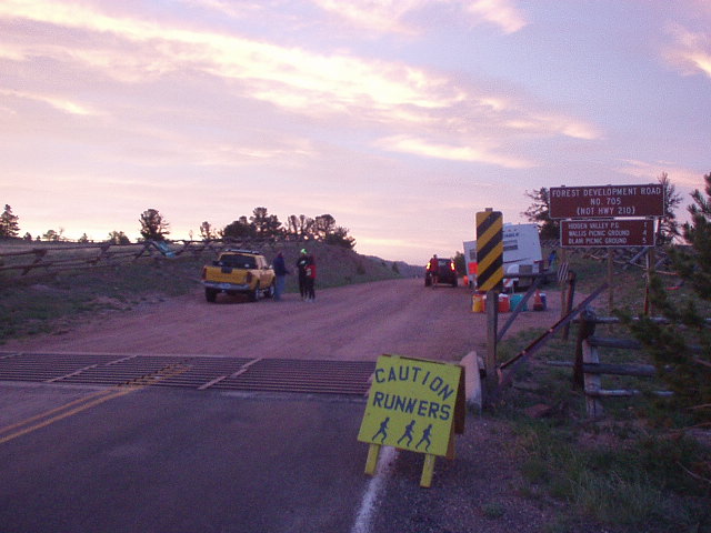 yellow sign saying Caution Runners, yellow truck, dirt trail