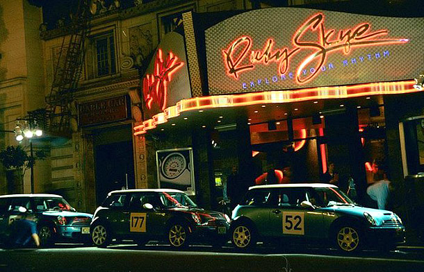 three mini coopers with numbers on their doors in front of the Ruby Skye in San Francisco at night