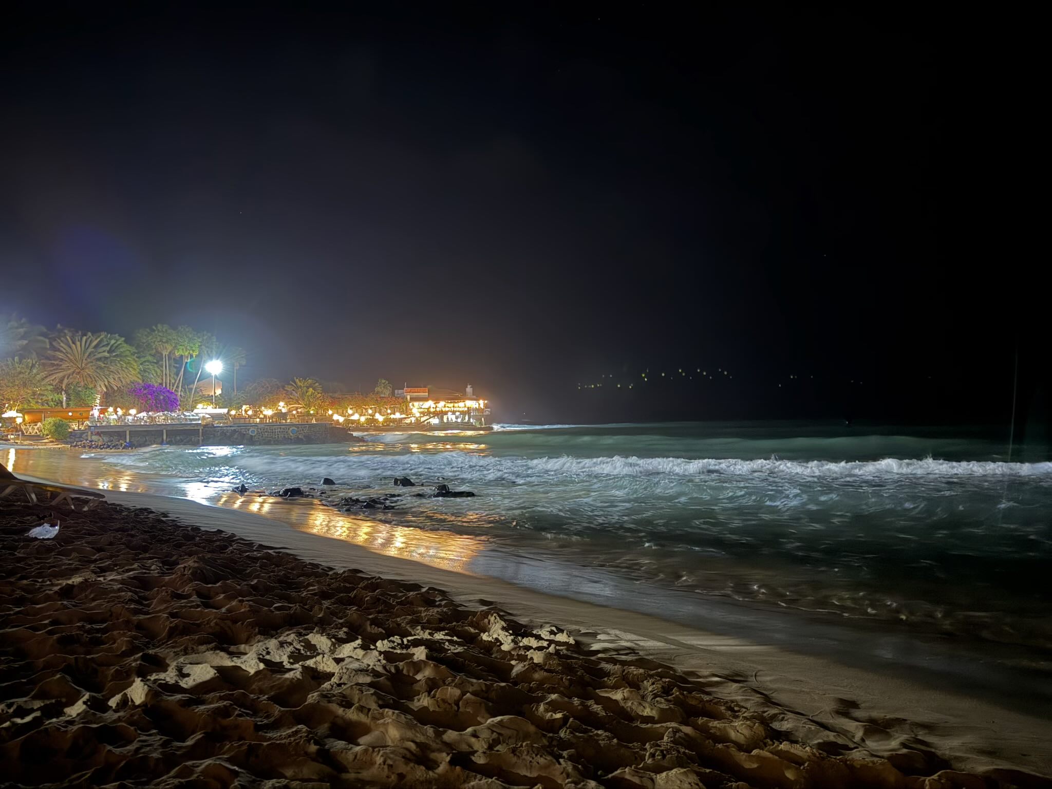 Ocean waves crashing against the Santa Maria Beach at night.