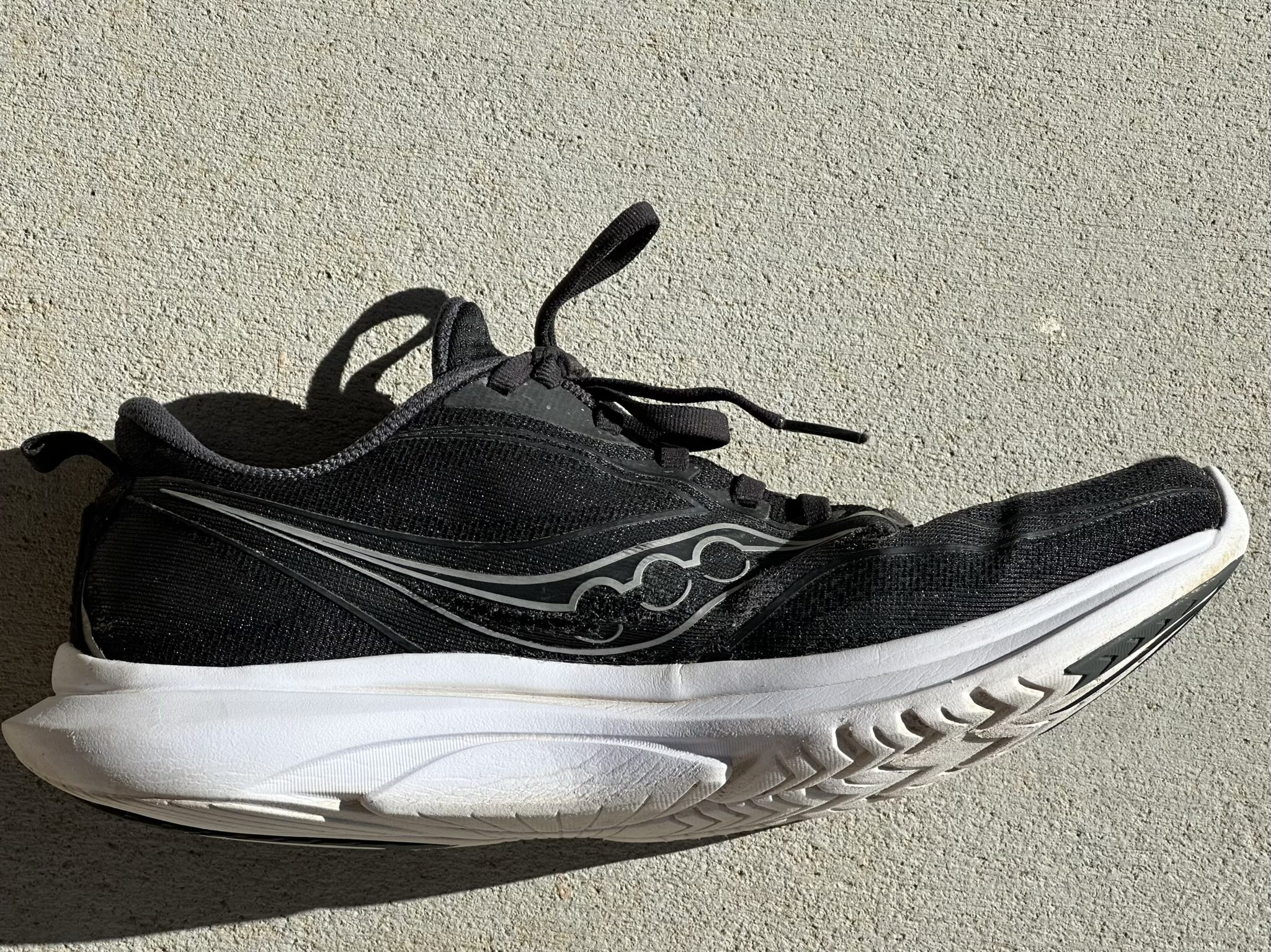 A black Saucony Kinvara 13 shoe after 660 miles. It's hard to see in this photo, but there is a lengthy stress tear in the uppers along the base of the Saucony logo. They only happen on the inner side of the foot.