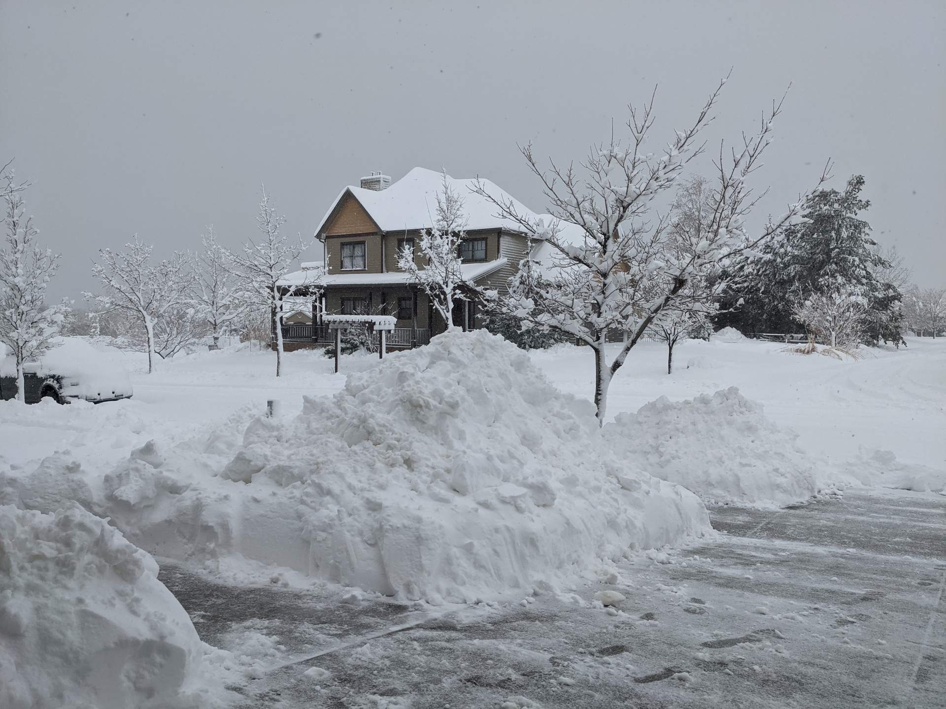 4-foot tall snowpile next to driveway with big house in north Fort Collins