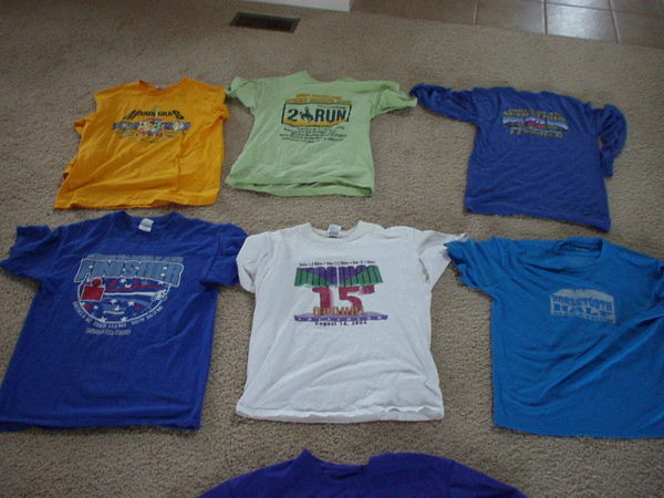 six T-shirts lying on the floor from running races