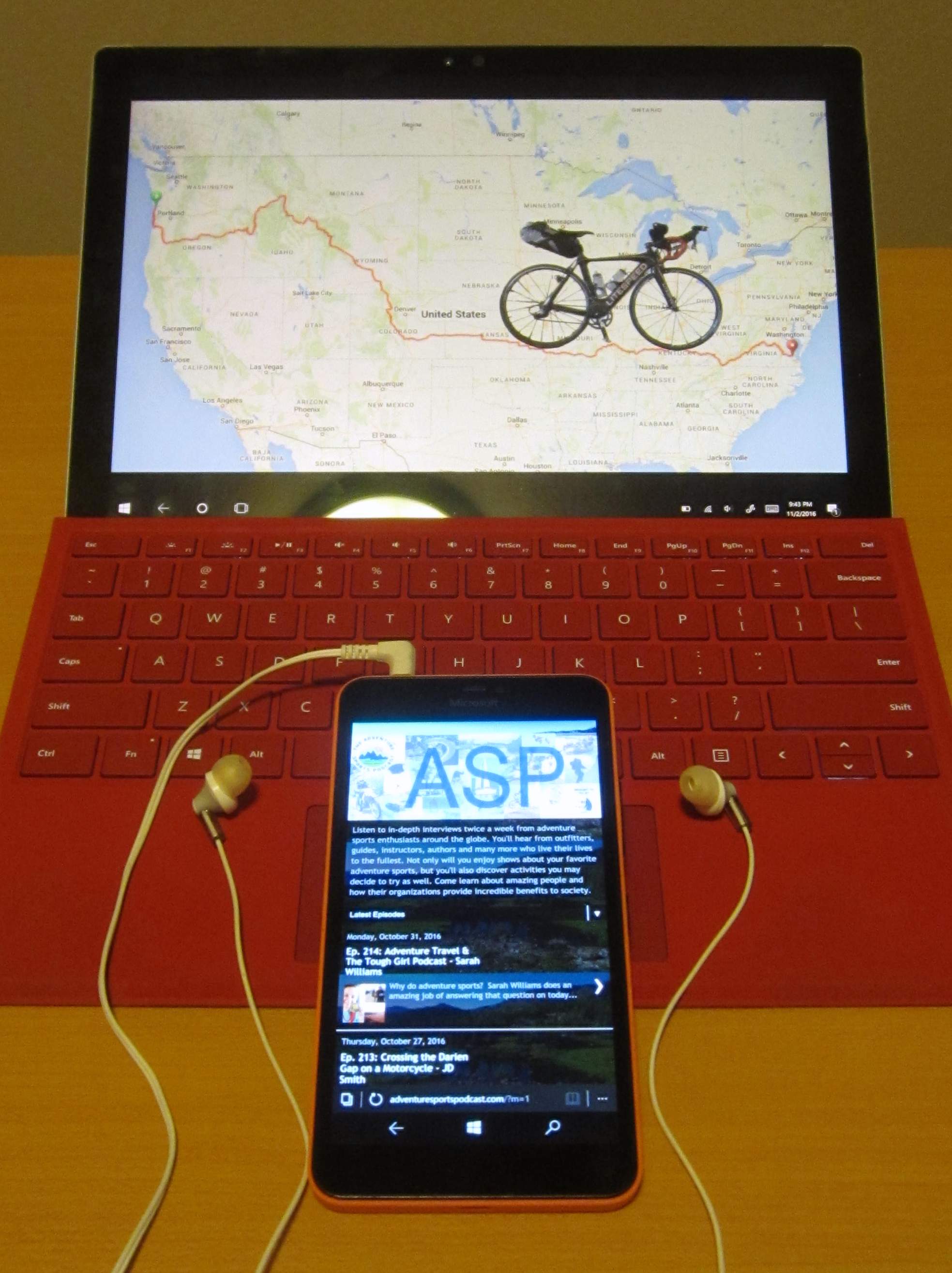 phone with headphones on red Microsoft Surface showing Trans Am Bike Race route