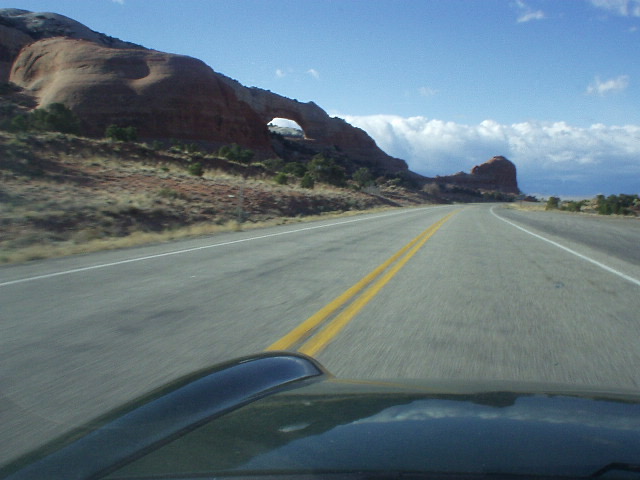 A sandstone formation with an arch, as seen over the hood of my Foglio Green Alfa Romeo Spider Veloce.