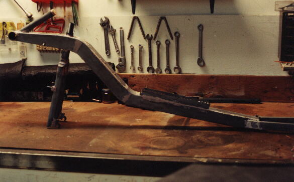 unpainted Reynolds Wishbone recumbent frame on a workbench