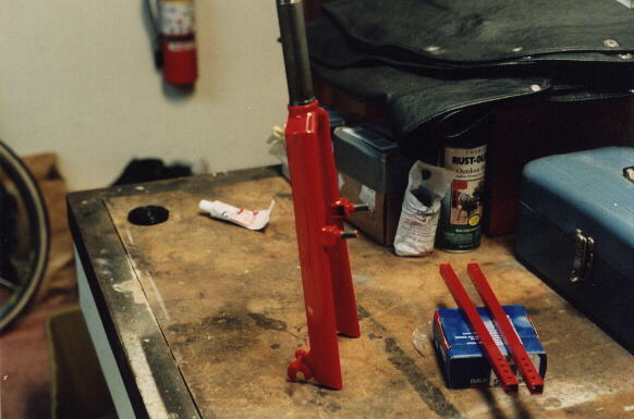 Reynolds Wishbone fork and seat stays painted Porsche Guards Red on top of workbench