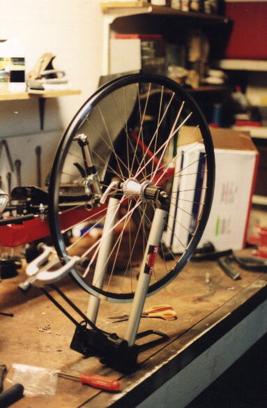 26-inch wheel on a Minoura truing stand on workbench
