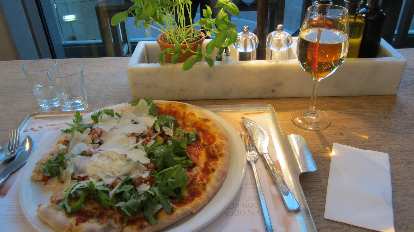 Enjoying a pizza with lots of vegetables and mozzarella in Vapiano. Enjoying a pizza with lots of vegetables and mozzarella in Vapiano.