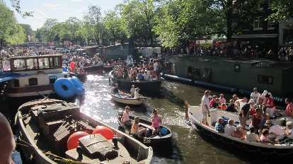People celebrating on boats on Canal Prinsengracht.