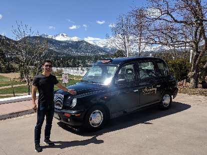 Felix Wong in front of a London Taxi at the Stanley Hotel in Estes Park.