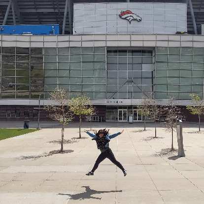 Vicky jumping in front of Mile High Stadium, where the Denver Broncos play their home games.