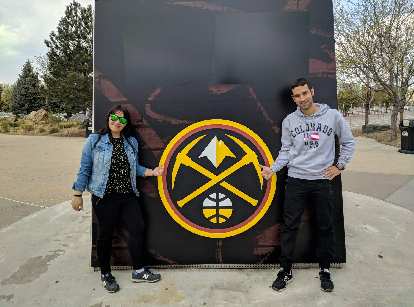 Vicky and Antxon in front of the Denver Nuggets new logo at the Pepsi Center.