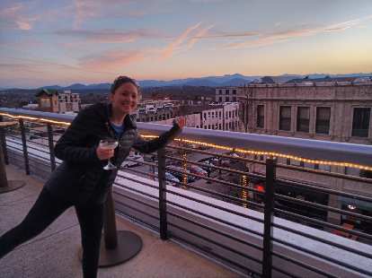 Maureen on the rooftop patio of Hemingway's Cuba in Asheville, with a nice sunset behind.